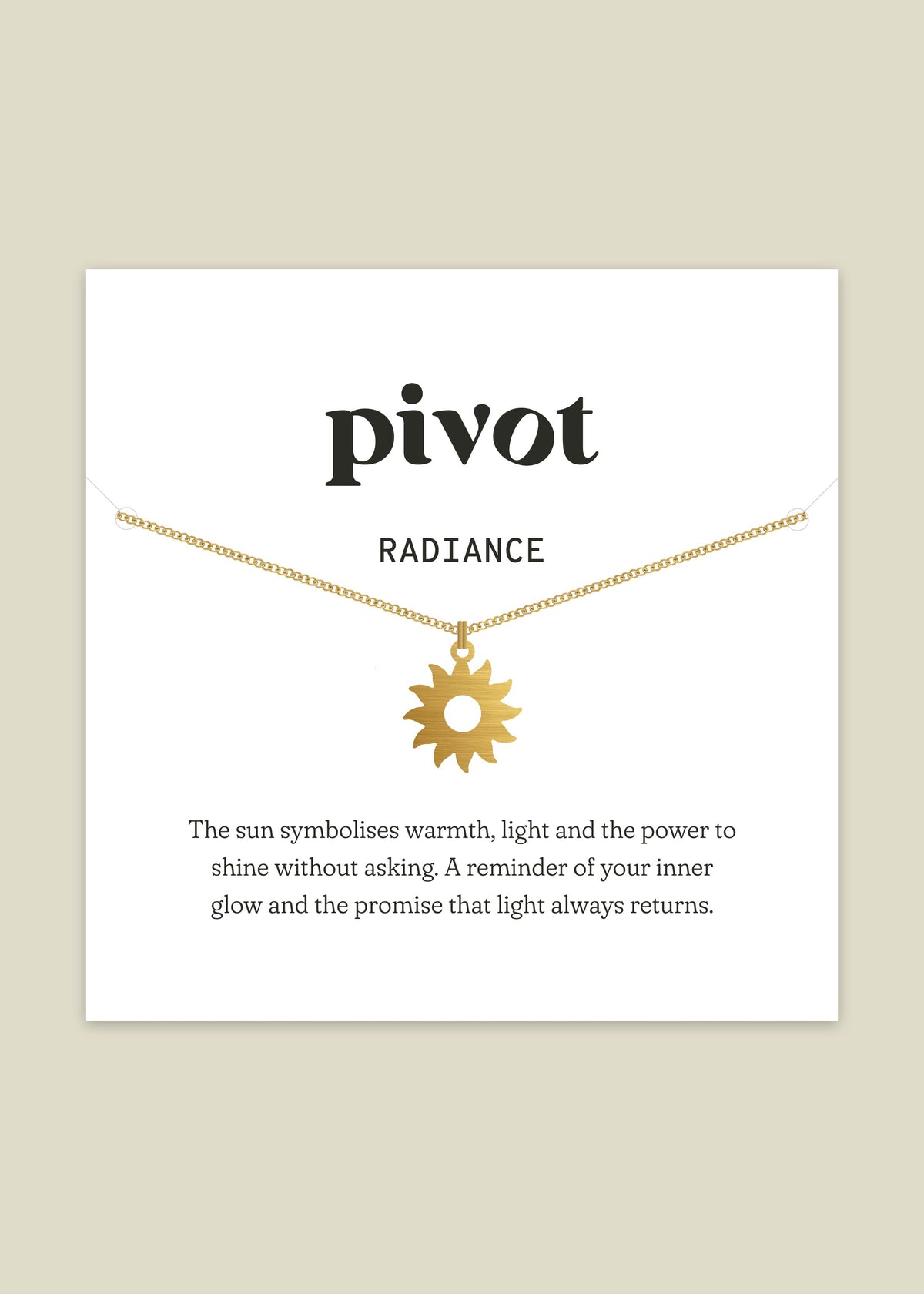Gold necklace with sun pendant on a white card with text about the symbol of the sun.